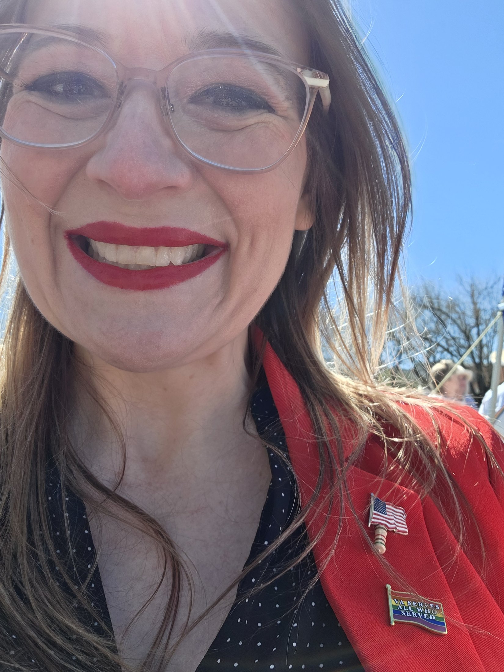 Bethany in a red blazer at an outdoor gathering